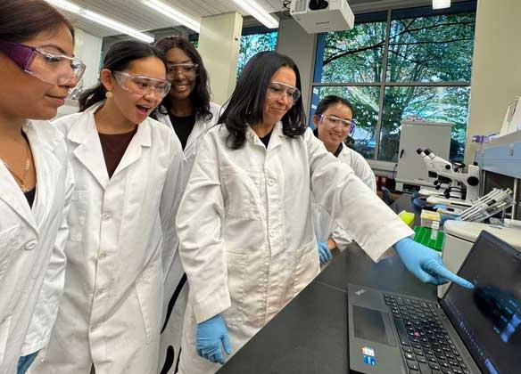 students and professor delgado in lab